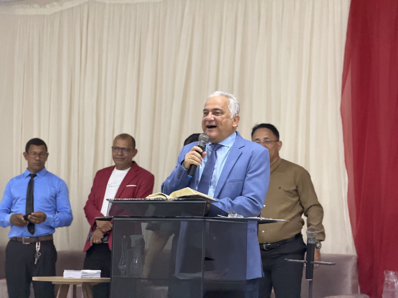Pastor Valadares pregando ao púlpito com a Bíblia aberta